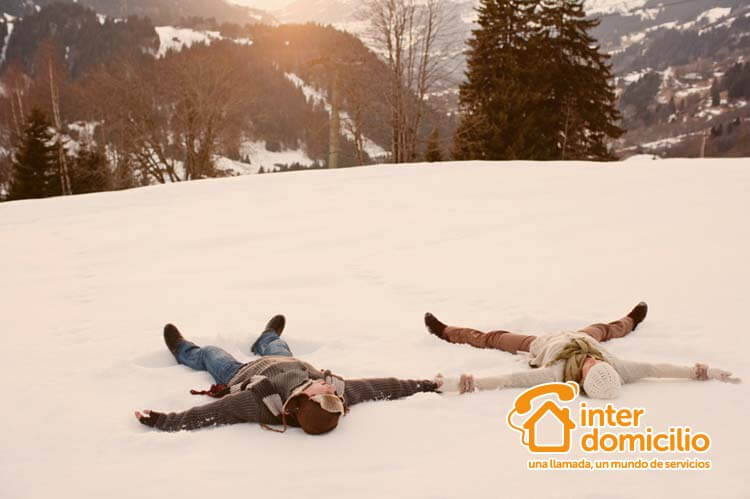dos personas haciendo el ángel en la nieve