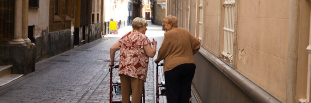 Señoras mayores caminando por la calle mientras hablan